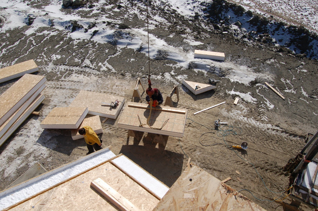 Employees lifting SIPs to be installed on a timber frame