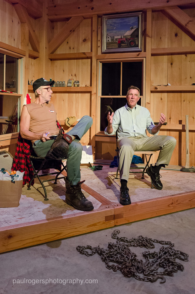 Two people on a stage in the timber frame barn
