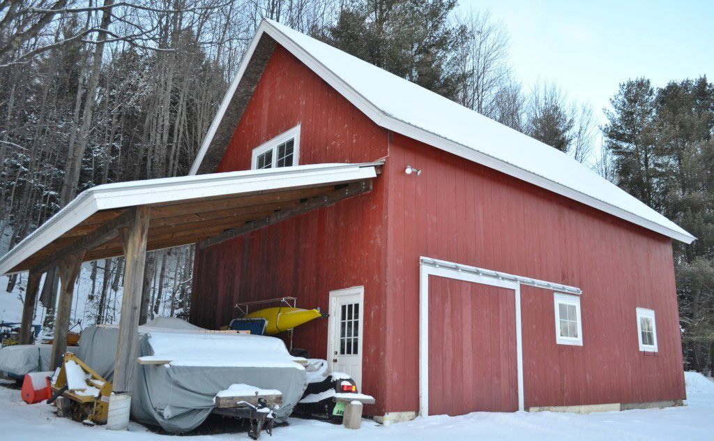 Finished exterior of a red timber frame barn in the winter