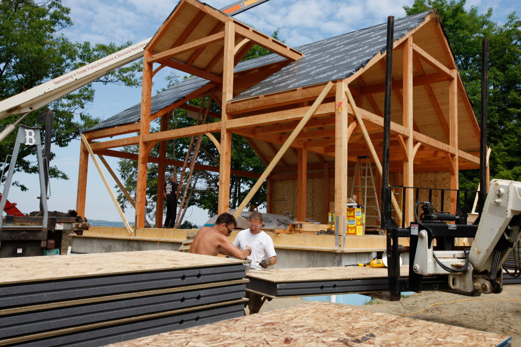 Employees working outside a timber frame cape structure