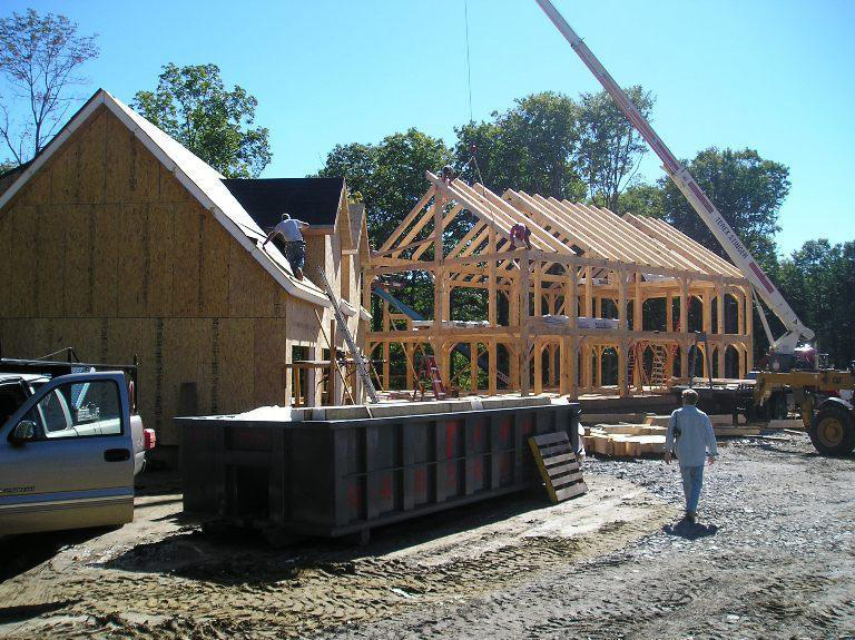 Vermont Frames employee on the roof of a timber frame colonial