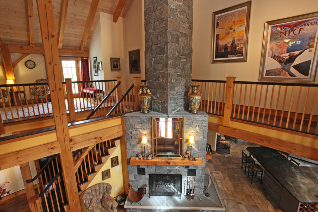 Stone chimney and fireplace in a timber frame colonial