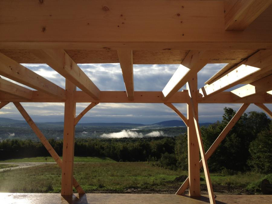 Underneath a timber frame colonial structure looking out at the mountains
