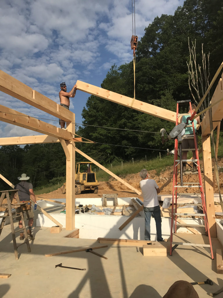 Employees working on a timber frame structure for a contemporary building