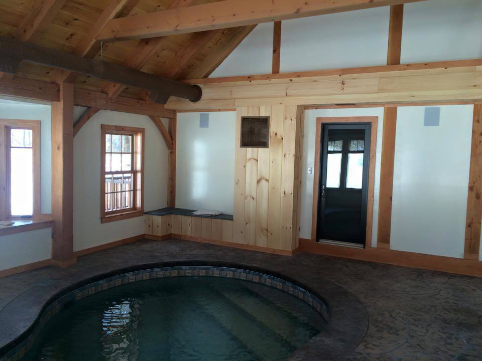 Indoor pool room in a timber frame dutch saltbox