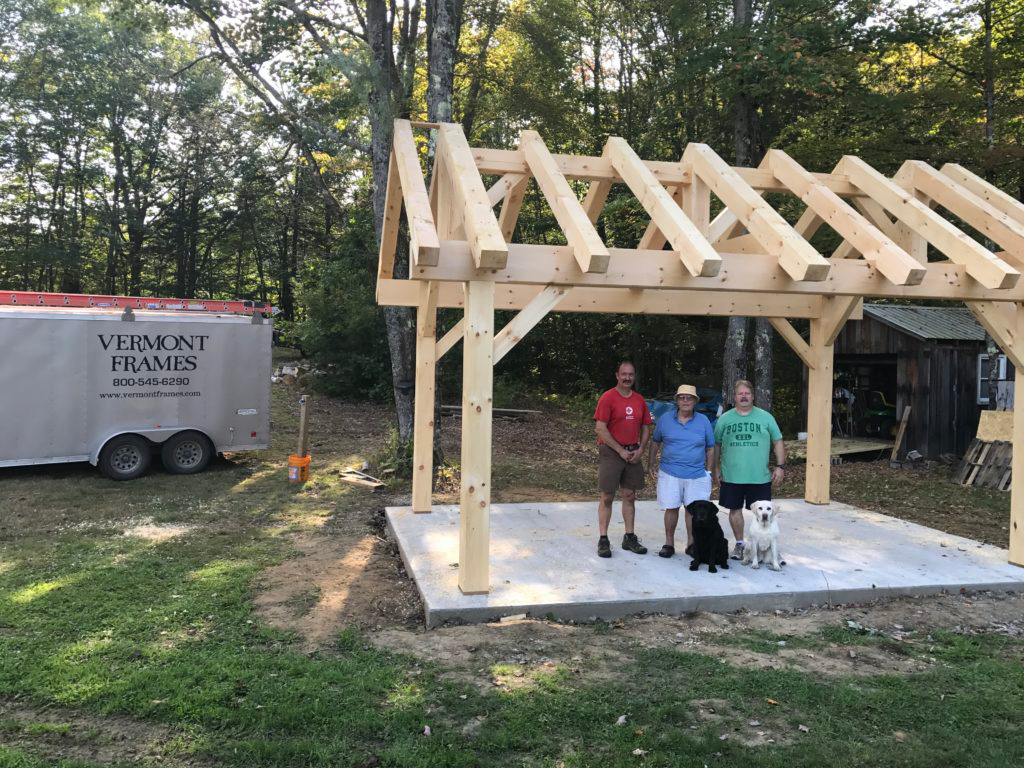Timber frame pavilion structure with 3 people and 2 dogs