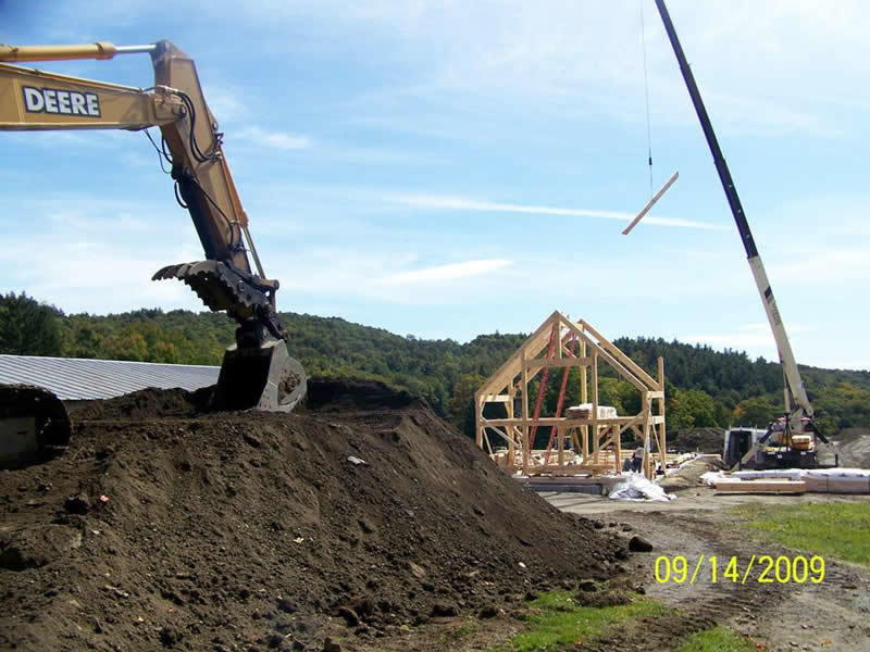 Backhoe and crane being used to build a timber frame restaurant