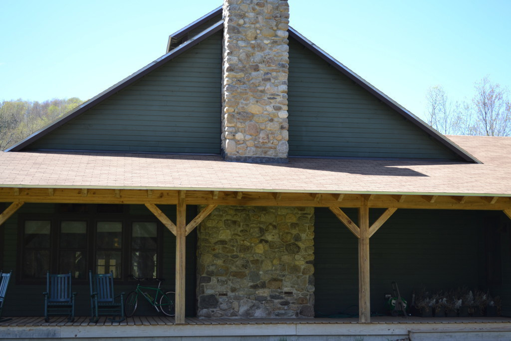 Finished exterior of a timber frame summer camp mess hall with a large stone chimney