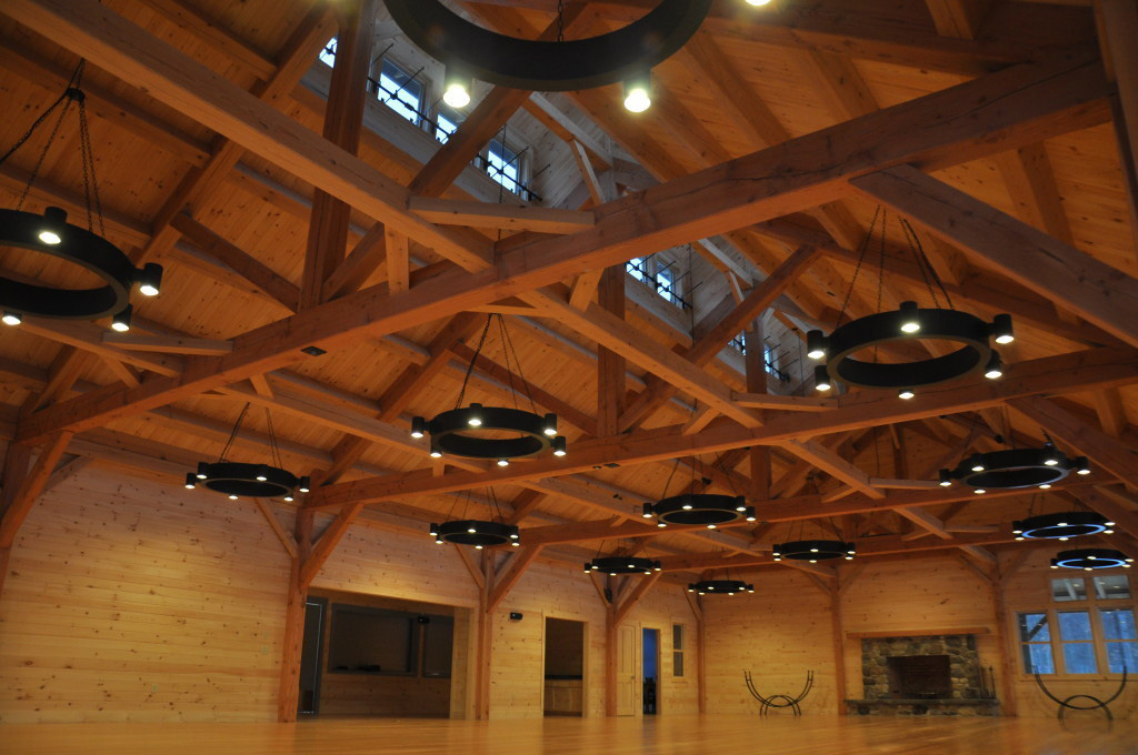 Timber frame ceiling in a summer camp mess hall with circular lighting