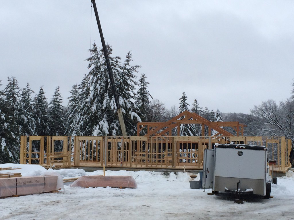 Timber frame structure of a summer camp pavilion with a crane