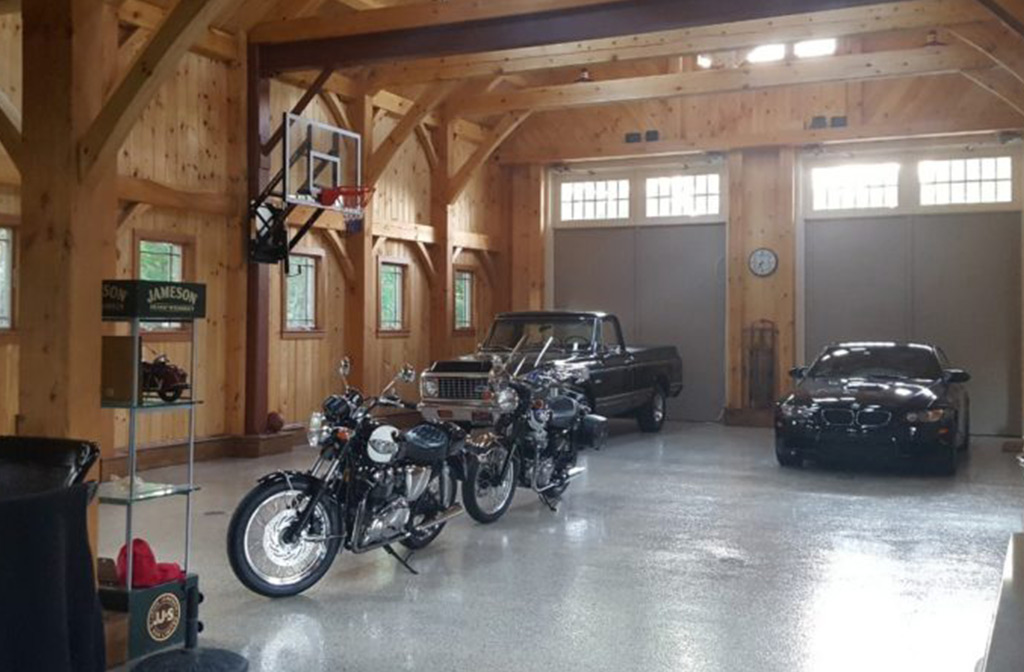 Finished timber frame barn interior with cars and motorcycles