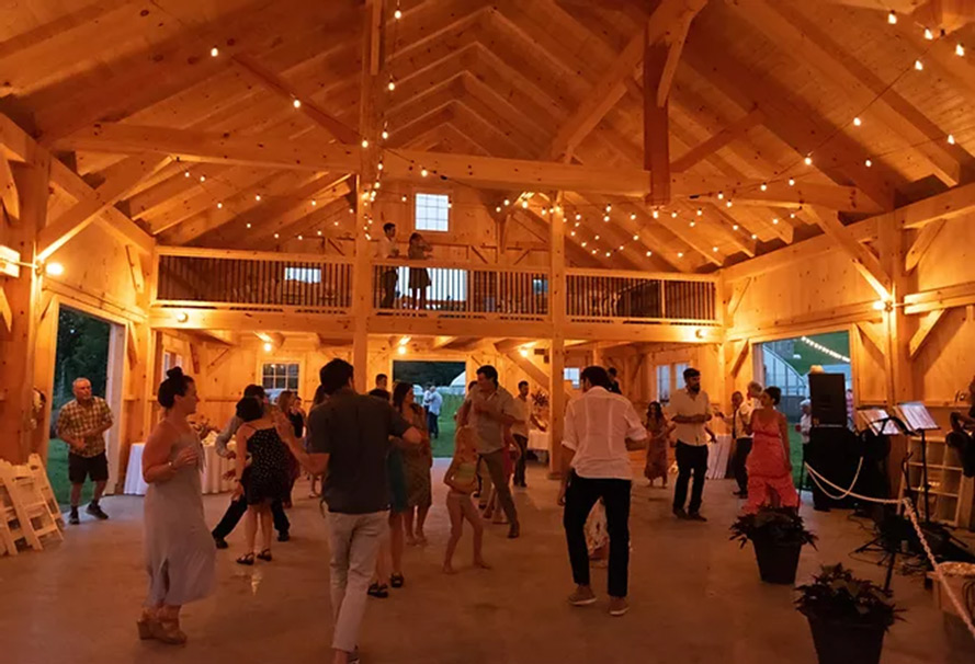Interior of a finished barn with people dancing