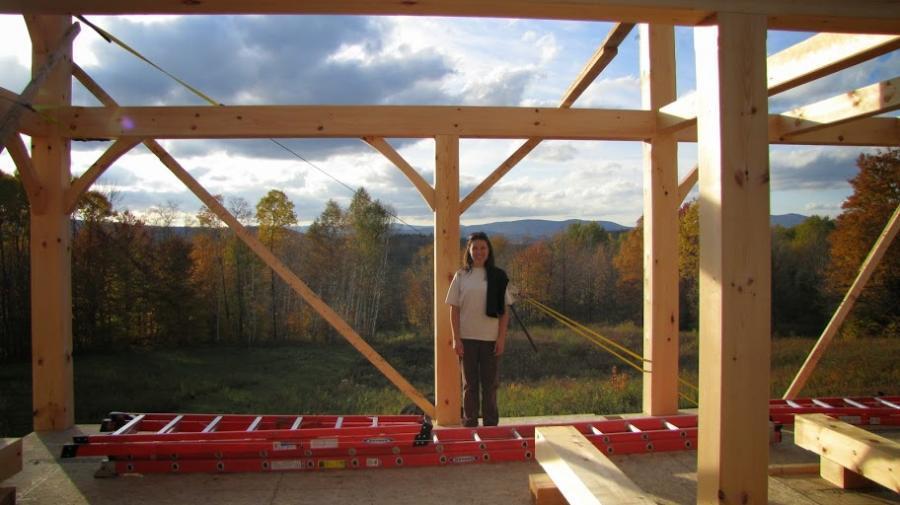 Girl standing in front of timber frame structure