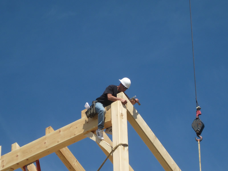 Man on timber frame colonial structure