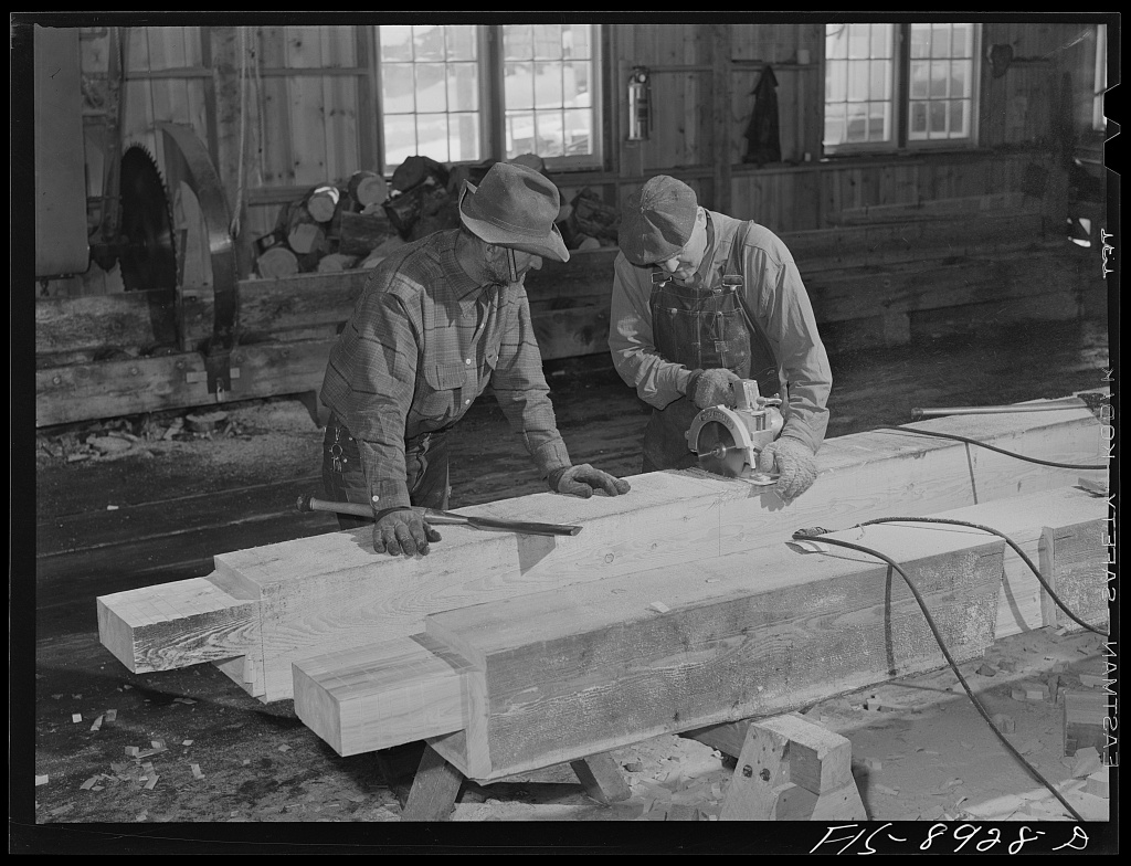 Early image of two timber framers in a shop cutting timbers