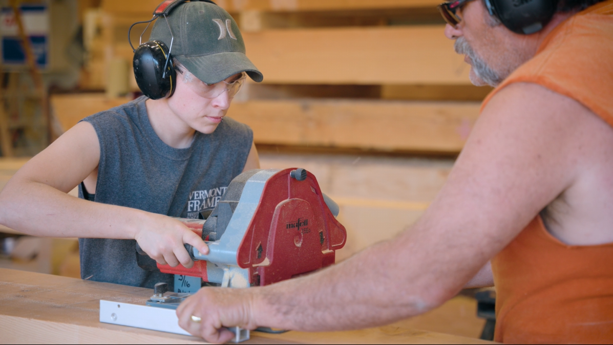 Shop Workers Using Bandsaw to Shape a Timber